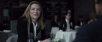 Movie still from “Tár” (2022), directed by Todd Field – A woman sitting at a table with a glass of wine; Close Up shot, Over the shoulder angle