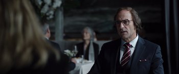 Movie still from “Tár” (2022), directed by Todd Field – A man sitting in front of a woman at a dinner table; Close Up shot, Over the shoulder angle