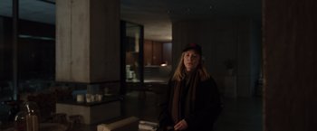 Movie still from “Tár” (2022), directed by Todd Field – A woman wearing a hat and a scarf in a room; Medium shot, Over the shoulder angle
