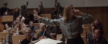 Movie still from “Tár” (2022), directed by Todd Field – A woman singing in front of an orchestra; Medium shot, Low angle