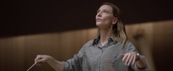 Movie still from “Tár” (2022), directed by Todd Field – A woman in a gray shirt is looking up at the ceiling; Close Up shot, Low angle
