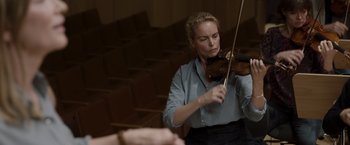 Movie still from “Tár” (2022), directed by Todd Field – A woman is playing the violin in an auditorium; Medium shot, Low angle