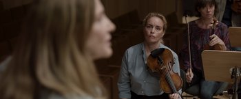 Movie still from “Tár” (2022), directed by Todd Field – A woman holding a violin in front of another woman; Close Up shot, Over the shoulder angle