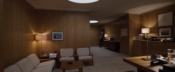 Movie still from “Tár” (2022), directed by Todd Field – A man standing in a living room next to a table; Wide shot, High angle