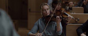 Movie still from “Tár” (2022), directed by Todd Field – A woman is playing the violin while another woman watches; Close Up shot, Low angle