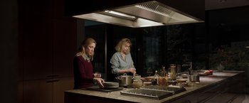 Movie still from “Tár” (2022), directed by Todd Field – Two women in a kitchen preparing food on a stove; Medium shot, Low angle