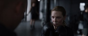 Movie still from “Tár” (2022), directed by Todd Field – A woman wearing boxing gloves in a boxing ring; Close Up shot, Over the shoulder angle