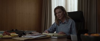 Movie still from “Tár” (2022), directed by Todd Field – A woman sitting at a desk in front of papers; Medium shot, Over the shoulder angle