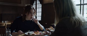 Movie still from “Tár” (2022), directed by Todd Field – A woman eating a plate of food at a table; Close Up shot, Over the shoulder angle