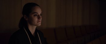 Movie still from “Tár” (2022), directed by Todd Field – A woman in a black jacket is looking to her left; Close Up shot, Over the shoulder angle