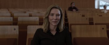 Movie still from “Tár” (2022), directed by Todd Field – A woman in a black shirt sitting in a room; Close Up shot, Over the shoulder angle