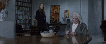 Movie still from “Tár” (2022), directed by Todd Field – Two people sitting at a wooden table with a bowl of clothes; Medium shot, Over the shoulder angle