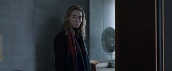 Movie still from “Tár” (2022), directed by Todd Field – A woman standing next to a fan in a room; Medium shot, Over the shoulder angle