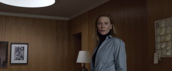 Movie still from “Tár” (2022), directed by Todd Field – A woman standing in front of a lamp in a room; Medium shot, Low angle