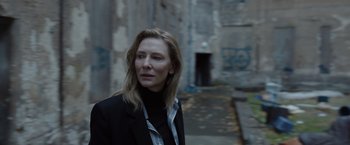 Movie still from “Tár” (2022), directed by Todd Field – A woman in a black jacket standing on a sidewalk; Close Up shot, Low angle