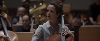 Movie still from “Tár” (2022), directed by Todd Field – A woman is holding a cello in her hands; Close Up shot, Low angle