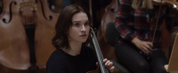 Movie still from “Tár” (2022), directed by Todd Field – A young woman holding a violin in her hands; Close Up shot, Over the shoulder angle