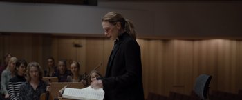 Movie still from “Tár” (2022), directed by Todd Field – A woman in a black jacket standing in front of sheet music; Medium shot, Over the shoulder angle