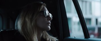 Movie still from “Tár” (2022), directed by Todd Field – A woman wearing glasses sitting in a car looking out the window; Close Up shot, Low angle