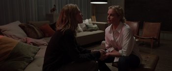 Movie still from “Tár” (2022), directed by Todd Field – Two women sitting on the floor in front of each other holding hands; Medium shot, Over the shoulder angle