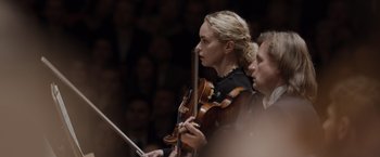 Movie still from “Tár” (2022), directed by Todd Field – A woman is holding a violin while a man looks on; Close Up shot, Low angle