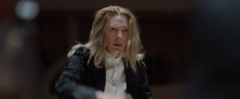Movie still from “Tár” (2022), directed by Todd Field – A woman with long blonde hair wearing a black jacket; Close Up shot, Low angle