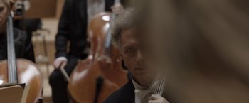 Movie still from “Tár” (2022), directed by Todd Field – A man in a tuxedo holding a fork in his hand; Extreme Close Up shot, Over the shoulder angle