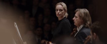 Movie still from “Tár” (2022), directed by Todd Field – A woman in a black shirt is standing in front of an audience; Close Up shot, Over the shoulder angle