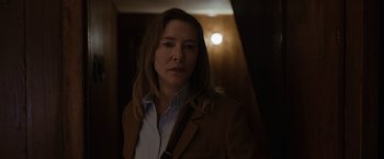 Movie still from “Tár” (2022), directed by Todd Field – A woman in a brown jacket is standing in a hallway; Close Up shot, Low angle