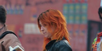 Movie still from “An Unforgettable Year: Autumn” (2023), directed by Lázaro Ramos – A woman with red hair and a leather jacket; Close Up shot, High angle