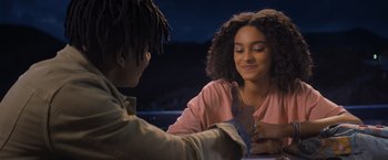 Two young people sitting at a table talking