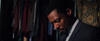 Movie still from “Unbreakable” (2000), directed by M. Night Shyamalan – A person wearing a suit and tie; Close Up shot, High angle