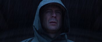Movie still from “Unbreakable” (2000), directed by M. Night Shyamalan – A man in a rain jacket and a hooded jacket; Close Up shot, Low angle