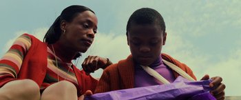 Movie still from “Unbreakable” (2000), directed by M. Night Shyamalan – A woman and a boy looking into a bag; Close Up shot, Low angle