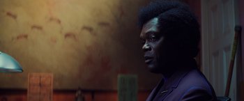 Movie still from “Unbreakable” (2000), directed by M. Night Shyamalan – A man with a black afro is looking into the distance; Close Up shot, Over the shoulder angle