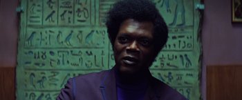 Movie still from “Unbreakable” (2000), directed by M. Night Shyamalan – A man in a purple jacket and a blue shirt; Close Up shot, Low angle