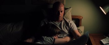 Movie still from “Unbreakable” (2000), directed by M. Night Shyamalan – A man and a child sleeping in a bed; Medium shot, High angle