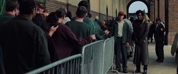 Movie still from “Unbreakable” (2000), directed by M. Night Shyamalan – A man standing next to a crowd of people; Medium shot, High angle