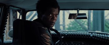 Movie still from “Unbreakable” (2000), directed by M. Night Shyamalan – A man sitting in the driver's seat of a car; Close Up shot, Over the shoulder angle