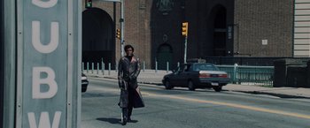Movie still from “Unbreakable” (2000), directed by M. Night Shyamalan – A man walking across the street in front of a traffic light; Wide shot, Low angle