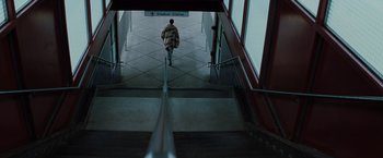 Movie still from “Unbreakable” (2000), directed by M. Night Shyamalan – A person walking down a set of stairs in a building; Extreme Wide shot, High angle