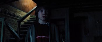 Movie still from “Unbreakable” (2000), directed by M. Night Shyamalan – A young boy standing in a dark room; Medium shot, Low angle