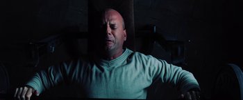 Movie still from “Unbreakable” (2000), directed by M. Night Shyamalan – A bald man with his arms outstreched and his eyes closed; Close Up shot, Overhead angle