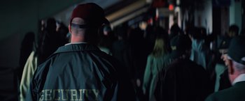 Movie still from “Unbreakable” (2000), directed by M. Night Shyamalan – A group of people walking down a train platform at night; Medium shot, Over the shoulder angle