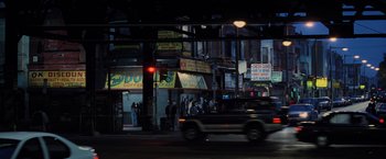 Movie still from “Unbreakable” (2000), directed by M. Night Shyamalan – A car driving down a street next to buildings; Extreme Wide shot, High angle