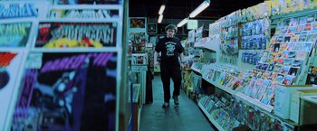 Movie still from “Unbreakable” (2000), directed by M. Night Shyamalan – A man walking down a hallway in a store; Medium shot, Over the shoulder angle