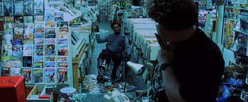Movie still from “Unbreakable” (2000), directed by M. Night Shyamalan – A man sitting in a wheelchair in a store; Wide shot, High angle