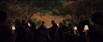 Movie still from “Unbreakable” (2000), directed by M. Night Shyamalan – A group of people sitting at a table in front of a tree; Wide shot, Low angle