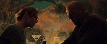 Movie still from “Unbreakable” (2000), directed by M. Night Shyamalan – A man and a woman sitting at a table with drinks in front of them; Close Up shot, Over the shoulder angle