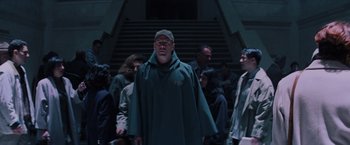 Movie still from “Unbreakable” (2000), directed by M. Night Shyamalan – A group of people standing in front of a staircase; Medium shot, Low angle